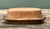 This vintage McCoy ceramic butter dish is a quintessential piece of American serving ware, embodying the warm, organic...