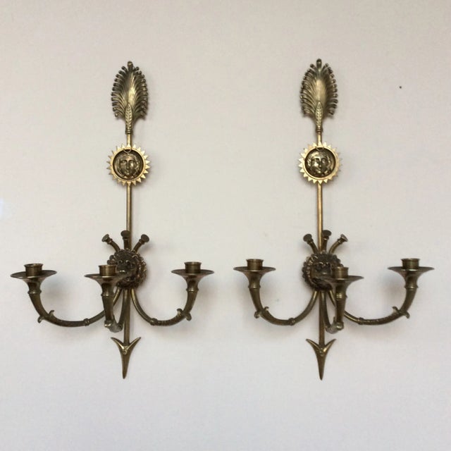 Fine pair of ormolu sconces with hunting horns as arms and arrows, lion heads, starbursts, feathers and faces. Each having...
