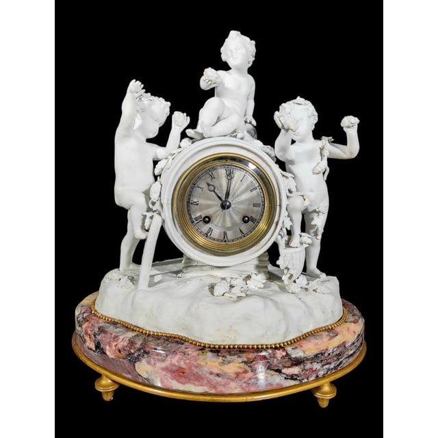 Porcelain clock by Le Roy Et Fills A Paris Elegant porcelain clock from the beginning of 1800 with a wine allegory scene....