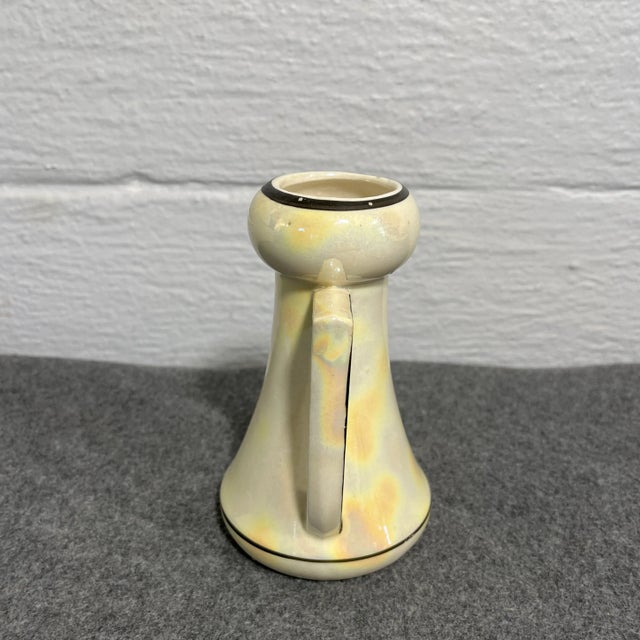 Beautiful form and lines with sleek dual handles. Creamy lusterware finish with an outline of black at rim and base.