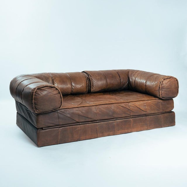 Vintage 1970s leather patchwork sofa/ double bed with a bold, sculptural design. This two-seat piece, showcasing unique...