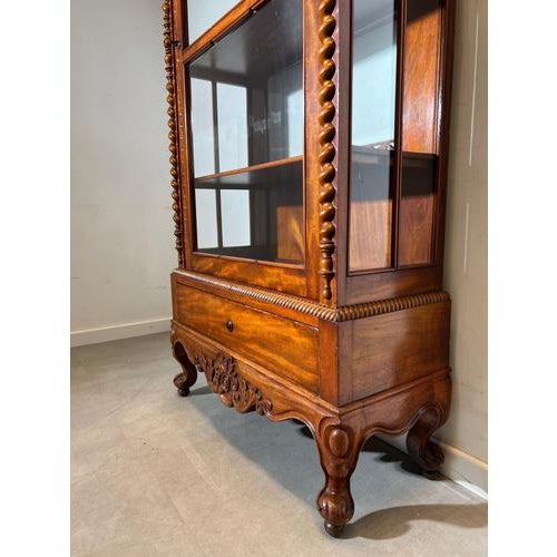 Beautiful antique display cabinet featuring elegant barley twist columns and a warm, rich wood tone. This refined vitrine...