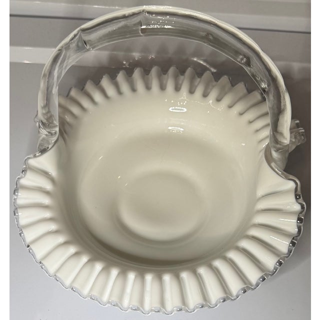 A classic vintage Fenton Silver Crest handled basket, crafted in luminous milk glass with a delicately hand-crimped clear...