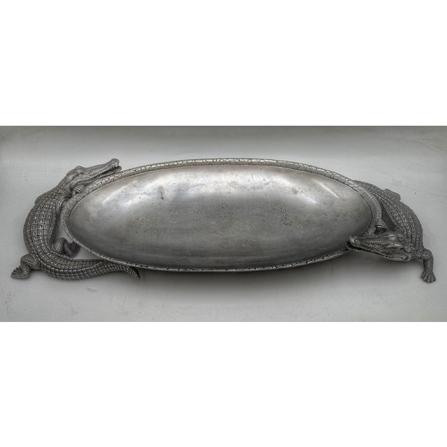 A striking Arthur Court cast aluminum oval serving tray featuring two finely detailed alligators supporting an elongated...