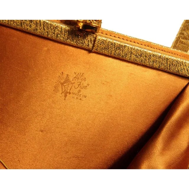 Vintage gold lame Kelly evening purse adorned with an elegant round dome pave rhinestone clasp in the centre. There are 2...