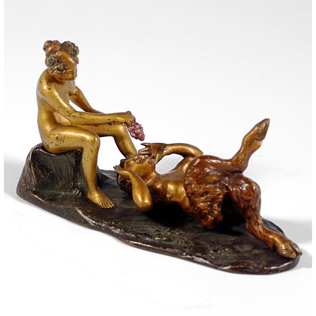 A faun lying on his back, his right leg raised onto his left knee; near his head, a female nude with her hair pinned up...