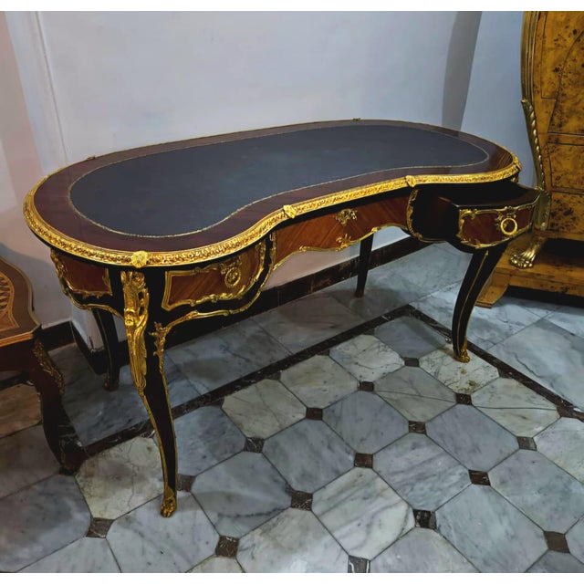 This elegant French Louis XV style writing desk showcases a sophisticated kidney-shaped silhouette, luxurious black...