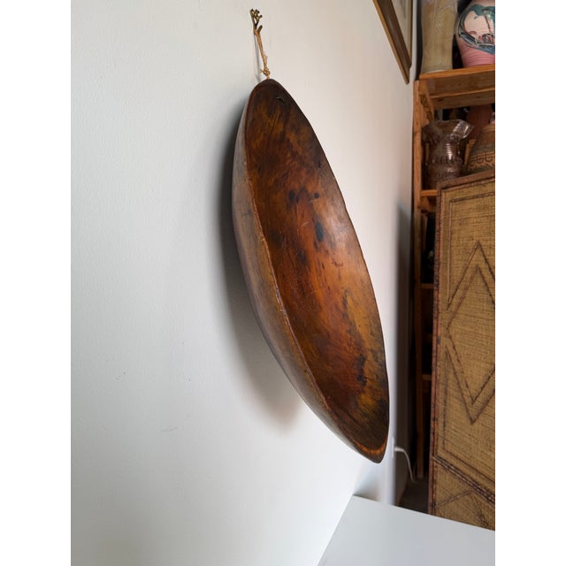 Vintage hand-carved wooden bowl featuring a beautiful primitive organic form and rich aged patina. This large shallow bowl...