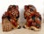A unique pair of Chinese carved hongmu oxblood Fu dogs with hominid facial features, the male with the latticed ball and...