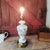 This vintage table lamp features elegant milk glass with a delicate gold floral design and brass accents. Its timeless...
