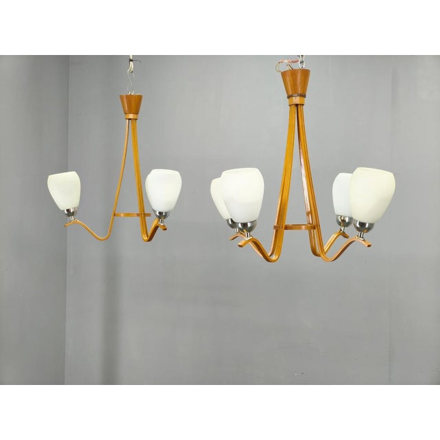 A rare pair of mid-century modern chandeliers manufactured by dřevo humpolec in czechoslovakia during the 1970s. The set...