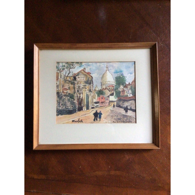 Set of three framed color prints by French artist Elis’ee Maclet. Number 1, Rue de l'Abreuvoir. It depicts a famous,...