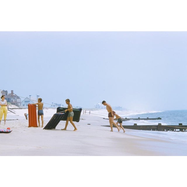 On The Hamptons Beach by Toni Frissell A family return to shore after a lilo adventure on the sea, Hamptons Beach, 1956....