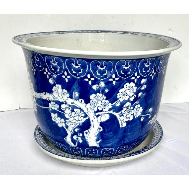 Late 1800s Chinese hand painted jardiniere with saucer. Overall traditional prunus blossom design with upper and lower...