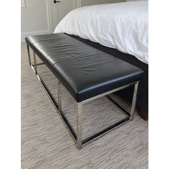 Mitchell Gold + Bob Williams Major bench ottoman in black leather with a polished stainless steel base. The leather top...