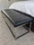 Mitchell Gold + Bob Williams Major bench ottoman in black leather with a polished stainless steel base. The leather top...