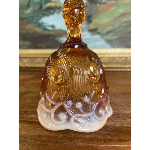 This vintage art glass bell features a rich amber-colored upper body over a white cased glass base, creating a warm, two-...