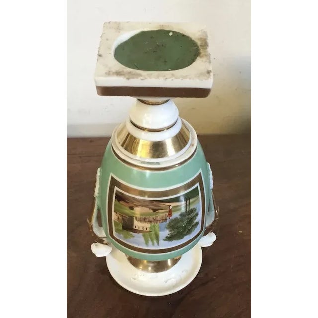 Small antique early 19th c. Paris porcelain vase decorated with a landscape scene and trophies on a light green ground...