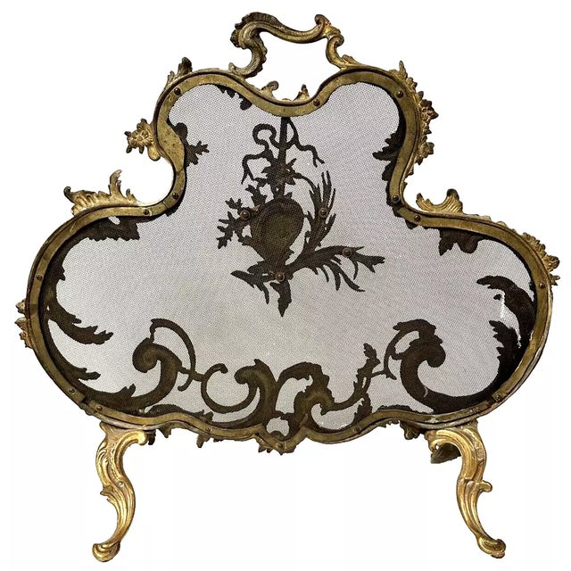 This is a beautiful French fireplace screen that has a very ornate brass design with scroll type border around the mesh...