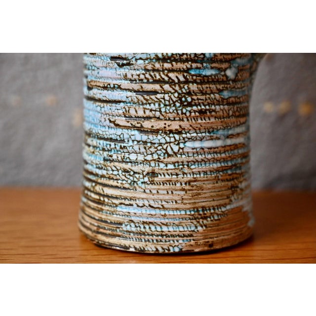 This generously sized pitcher draws its inspiration from nature. Ringed along its entire height, the jug also features a...