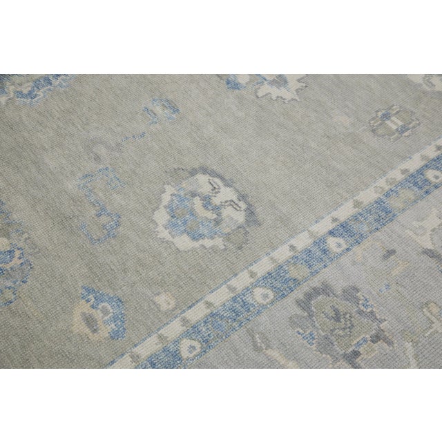 This modern Turkish Oushak rug is a stunning piece of art that has been handwoven using traditional techniques by skilled...