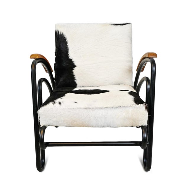 Deco black and white cowhide upholstered arm chair. Striking simple yet unique patterns of black and white. Each unique...