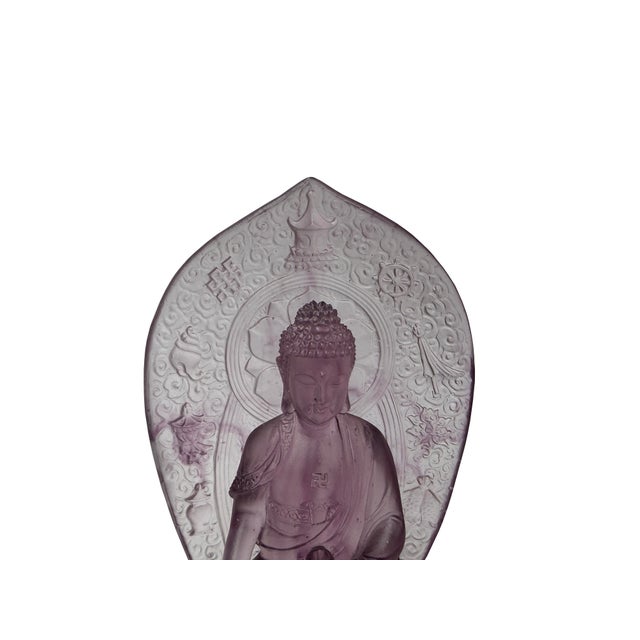This Amethyst Purple glass sculpture features a seated Buddha in a meditative pose atop an ornate lotus pedestal. Crafted...