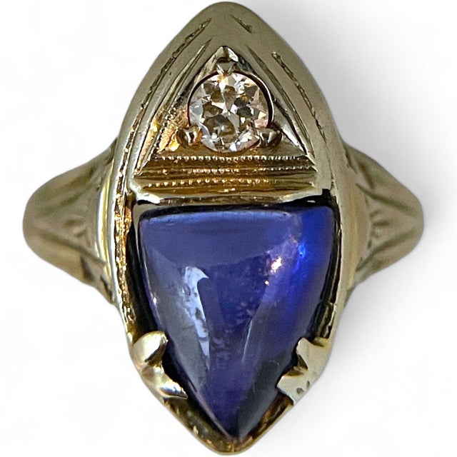 This exquisite ring features a striking synthetic marquise-cut sapphire set in 18K white gold, crowned with a sparkling...