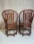 Beautiful pair of rattan arm chairs Leather strapping accents Reddish brown coloration Near perfect condition Fabulous style