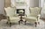 A handsome pair of mid-20th century French Louis XV–style wingback chairs, featuring finely carved walnut frames with...