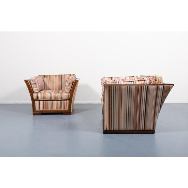 Beautiful pair of sculptural lounge armchairs designed in Italy 1980’s. It features stained wood frame with spectacular...