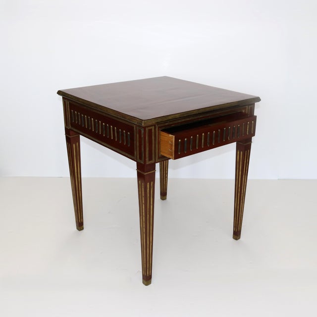 A fine Neoclassical-style square table. The highly figured mahogany timber is enhanced with patinated brass inlay. There...