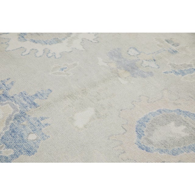 This modern Turkish Oushak rug is a stunning piece of art that has been handwoven using traditional techniques by skilled...