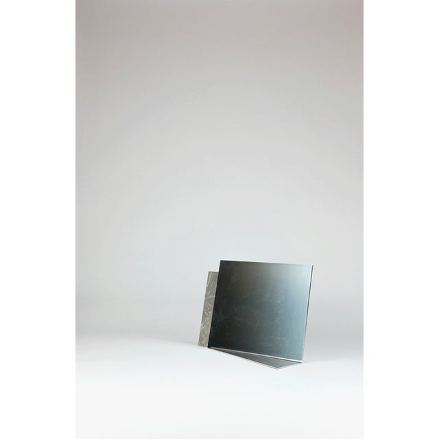 In Svelate Assenze, matter and reflection meet along a precise line of intersection. Fior di Bosco marble embraces the...