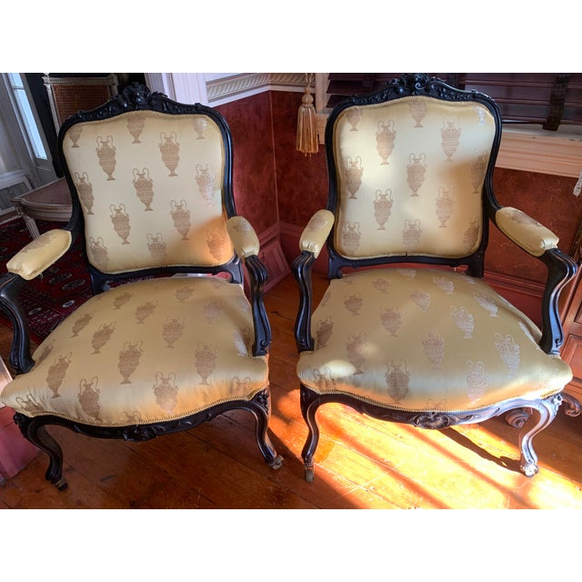 Pair of gorgeous upholstered French Louis XV arm chairs, solid wood, wonderful gold patterned urns, accompanied by...