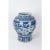 This blue and white temple vase features birds flying in a sky with clouds, framed by trees and a collar of medallions and...