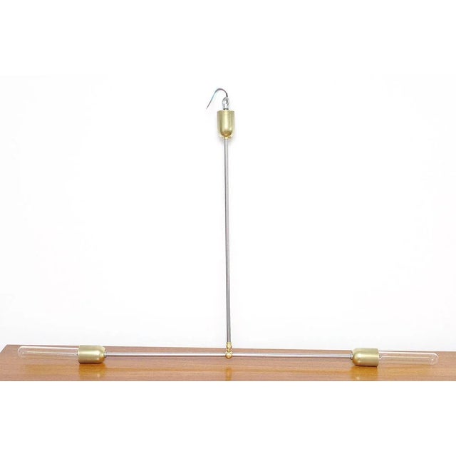This handmade minimal lamp is made of steel tubes and brass elements in a brushed finish. The horizontal arm can be set at...