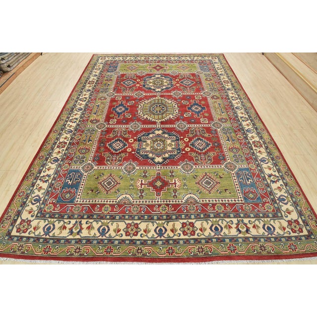 A tribal Caucasian Kazak rug hand-knotted with an all-wool pile on a cotton foundation. This oriental rug features...