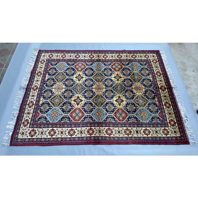 This hand-knotted Afghan wool rug is inspired by the renowned Persian Kashan style, featuring a stunning deep blue field...