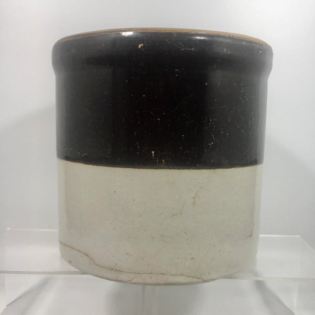 This 19th century stoneware crock features a two-tone glaze of tan and rich chocolate brown. Dimensions: 8.5" x 8.5" x...