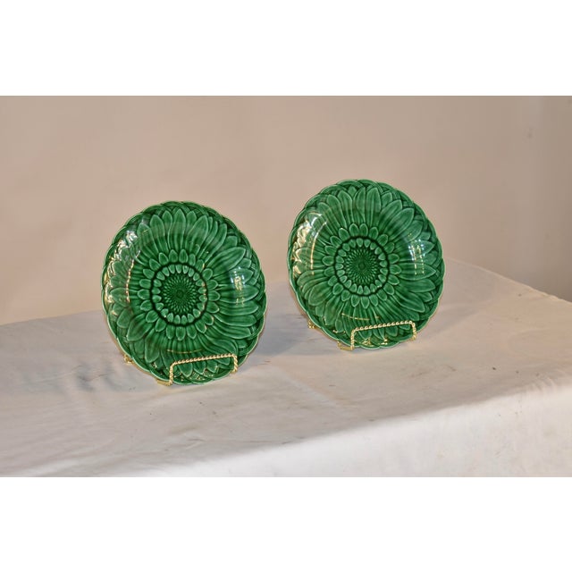 Pair of signed Wedgwood green Majolica plates in the highly collectible sunflower pattern. The plates are in a rich and...