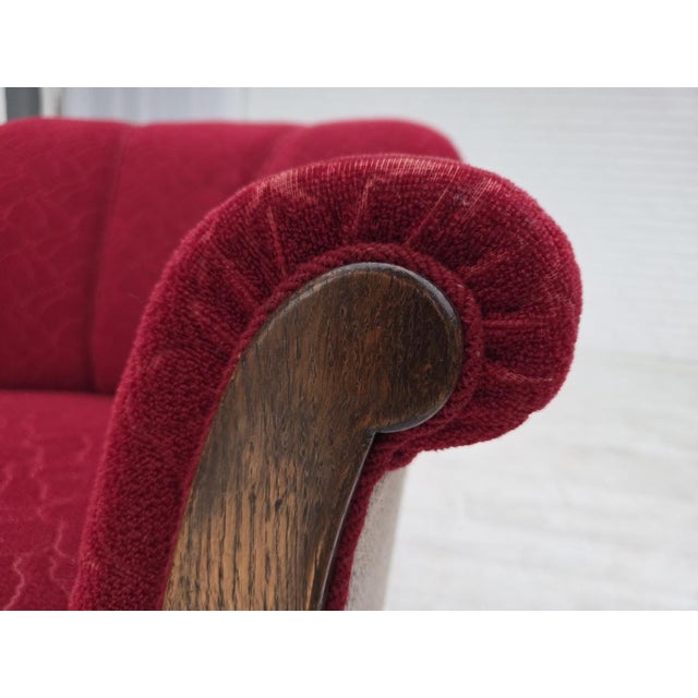 1950s, Danish armchair. Original red and light grey furniture wool, carved oak wood, brass springs in the seat. Original...