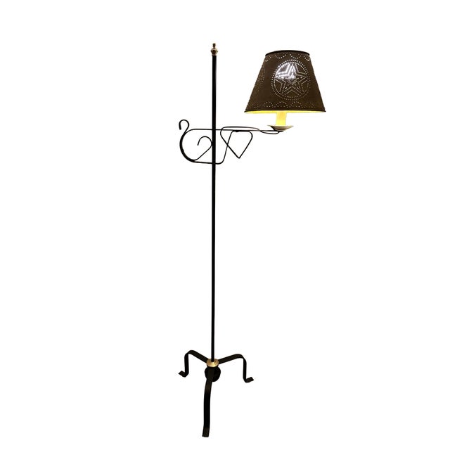 This Americana-style floor lamp features a hand-forged wrought iron tripod base and an adjustable punched tin shade with a...