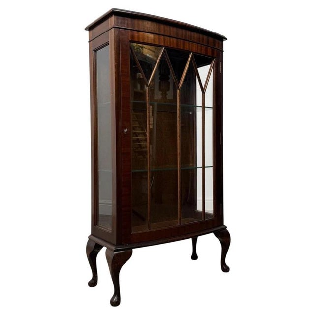 A charming and elegantly proportioned 20th-century mahogany display cabinet, combining practical display space, refined...