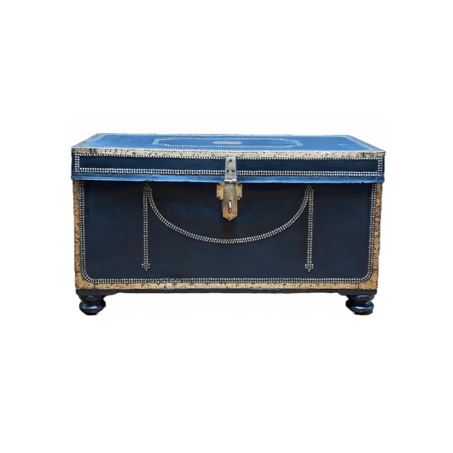 China trade brass bound black leather covered camphor wood trunk. The top and case are framed by brass corner mounts and...