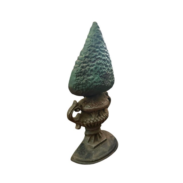 A charming, vintage cast iron door stop. Features a cast iron door stop in the form of a boxwood topiary in a handled urn....