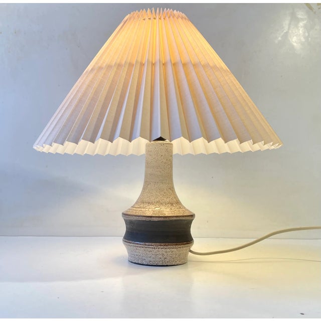 Stonware table light decorated in earthy speckled dark brown glazes upon a creme white background. It has no signature or...