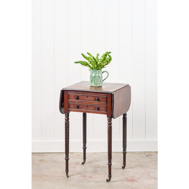 This Regency pembroke side table features two drawers with original wooden knobs, framed by curved drop leaves that can be...
