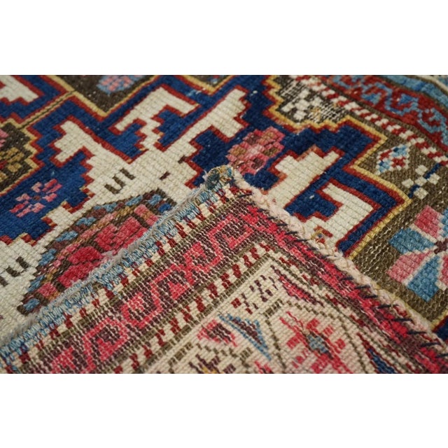 The abrashed red field of this small east Caucasian scatter shows well-covered by three conjoint cream and dark blue 12...