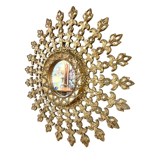 A striking large-scale mid-century sunburst mirror, masterfully crafted in carved giltwood with exceptional detail and...